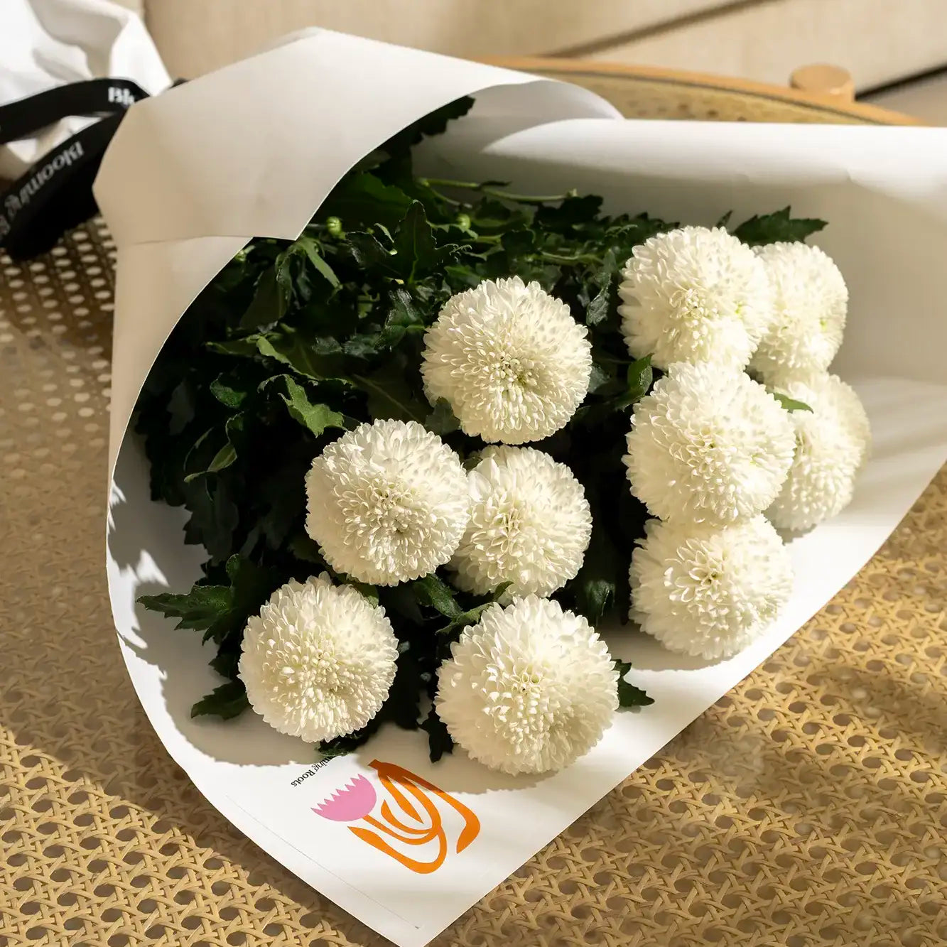 Flower bouquet wrapped in a white wrapping sheet with white flowers