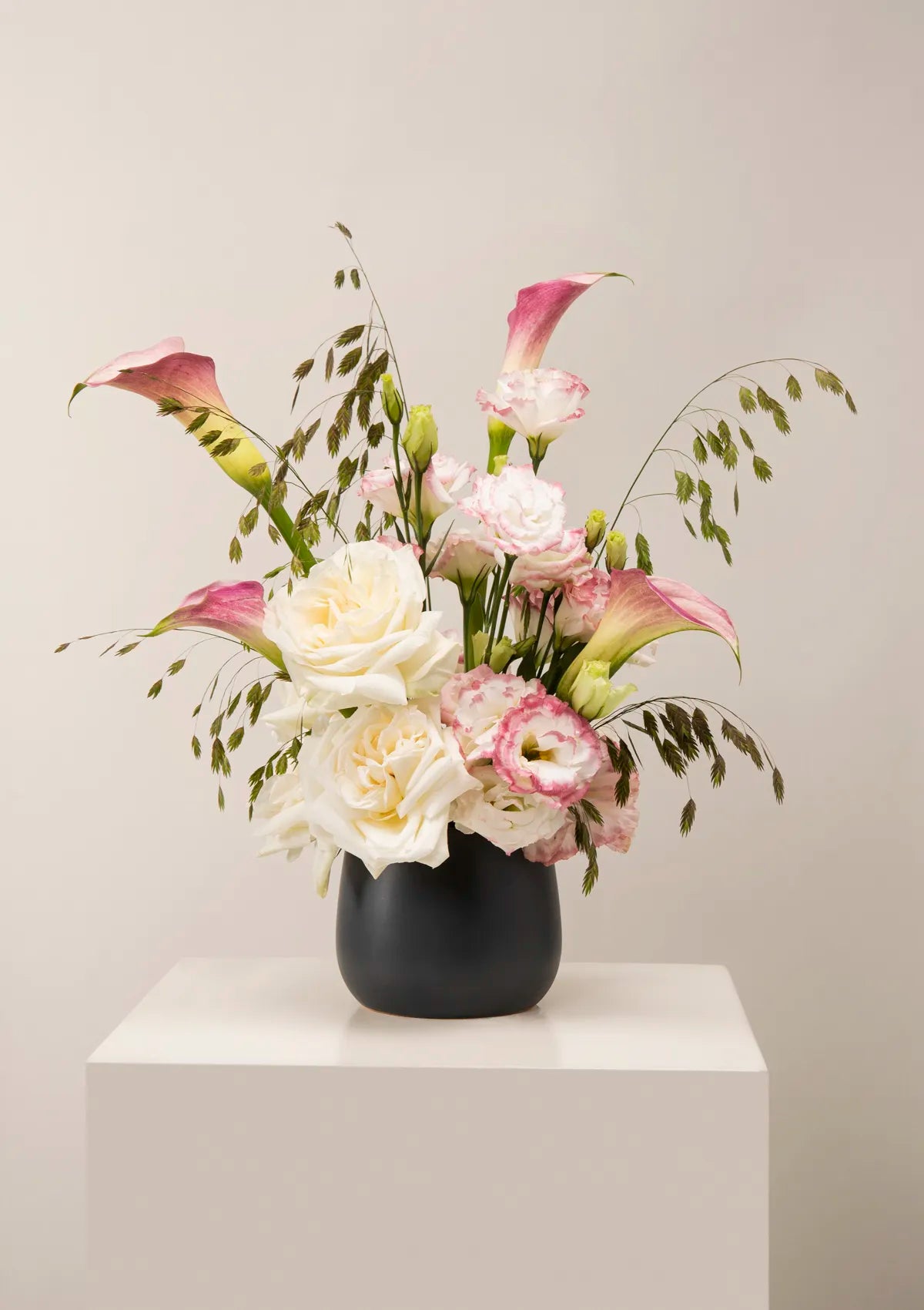 Grey Ceramic Grace Vase by Blooming Roots with white and pink flowers.