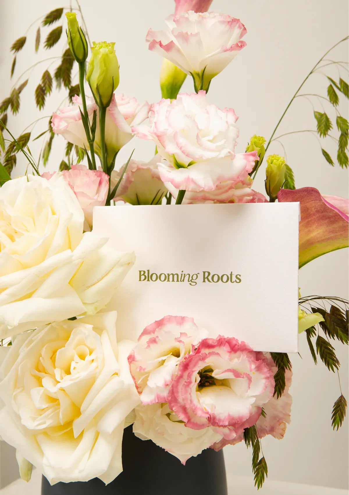 Grey Ceramic Grace Vase by Blooming Roots with a greeting card that has a logo on it.