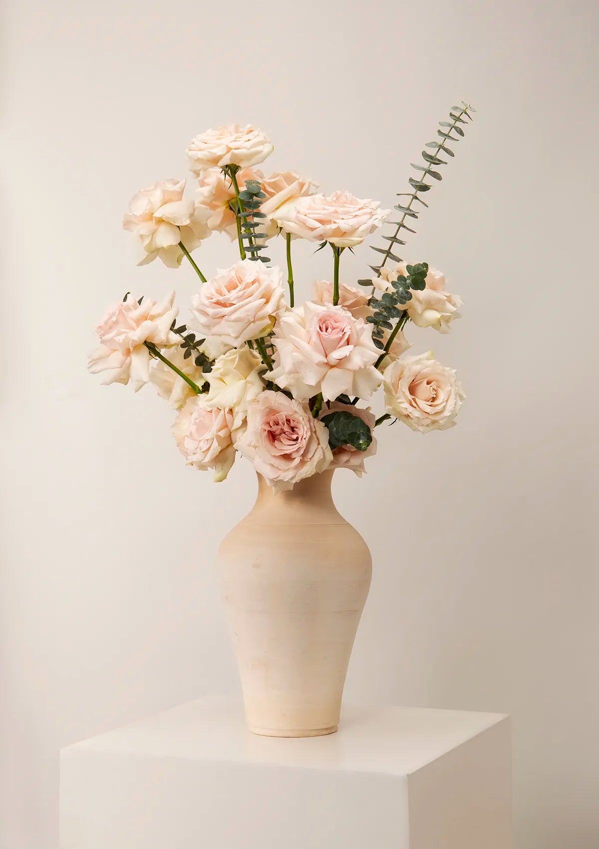 Clay light Beige Quicksand Vase by Blooming Roots with white and pink roses, and greenery.