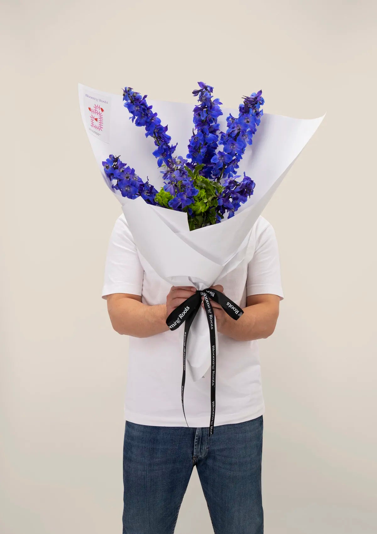 A man holding Seafoam Bouquet from Blooming Roots.