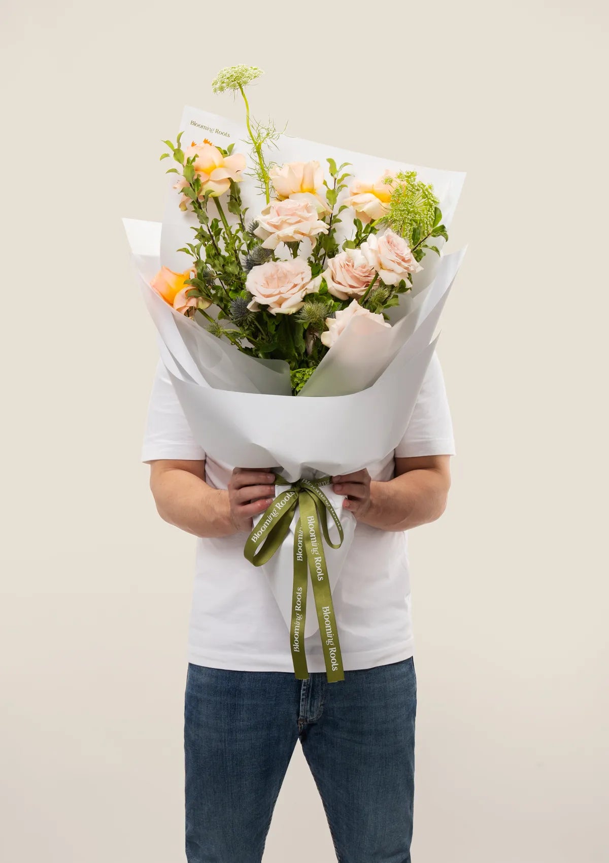 A man holding Secret Garden Bouquet from Blooming Roots.