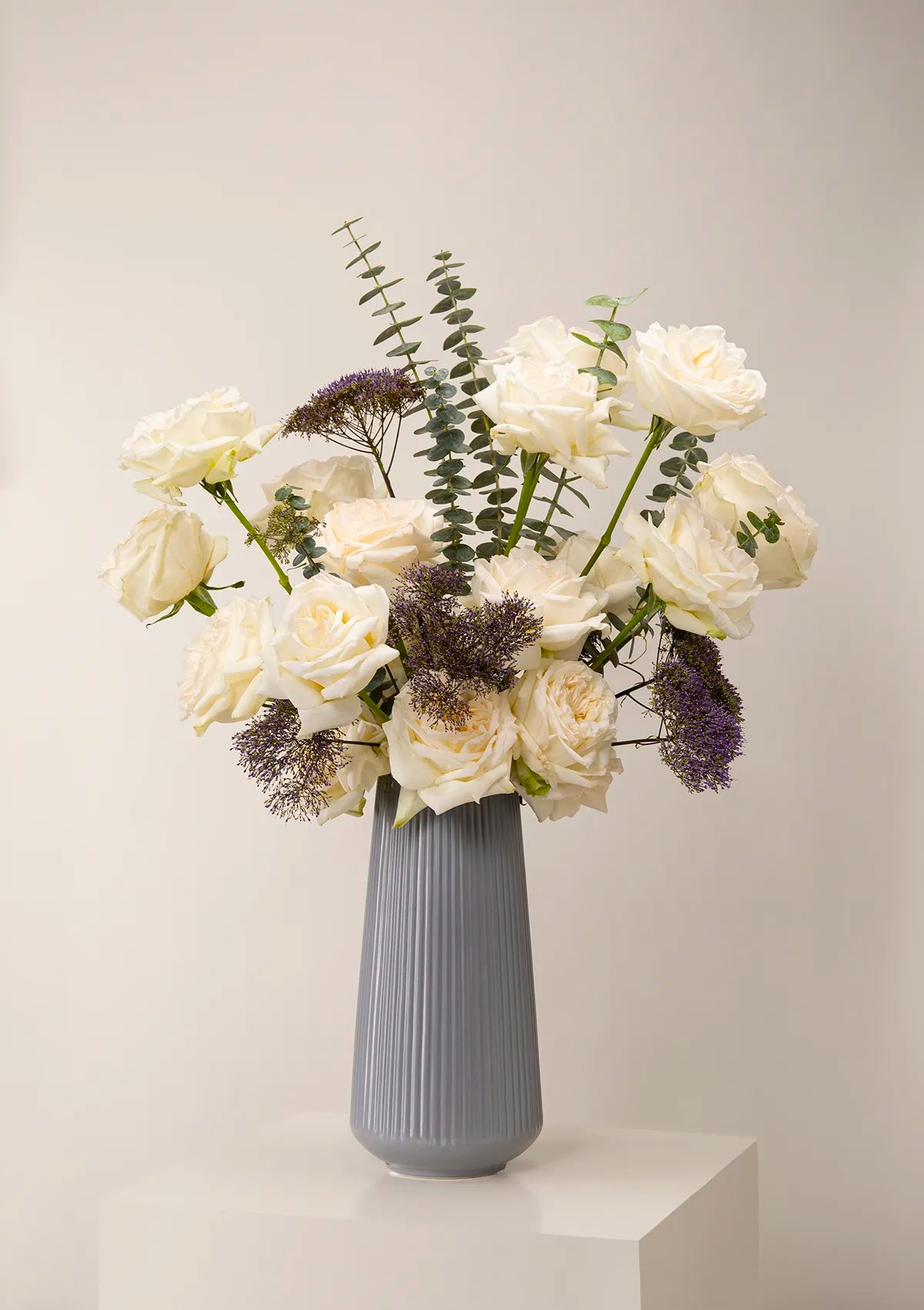 Grey Ceramic Serene Vase by Blooming Roots with White, purple, and greenery flowers.