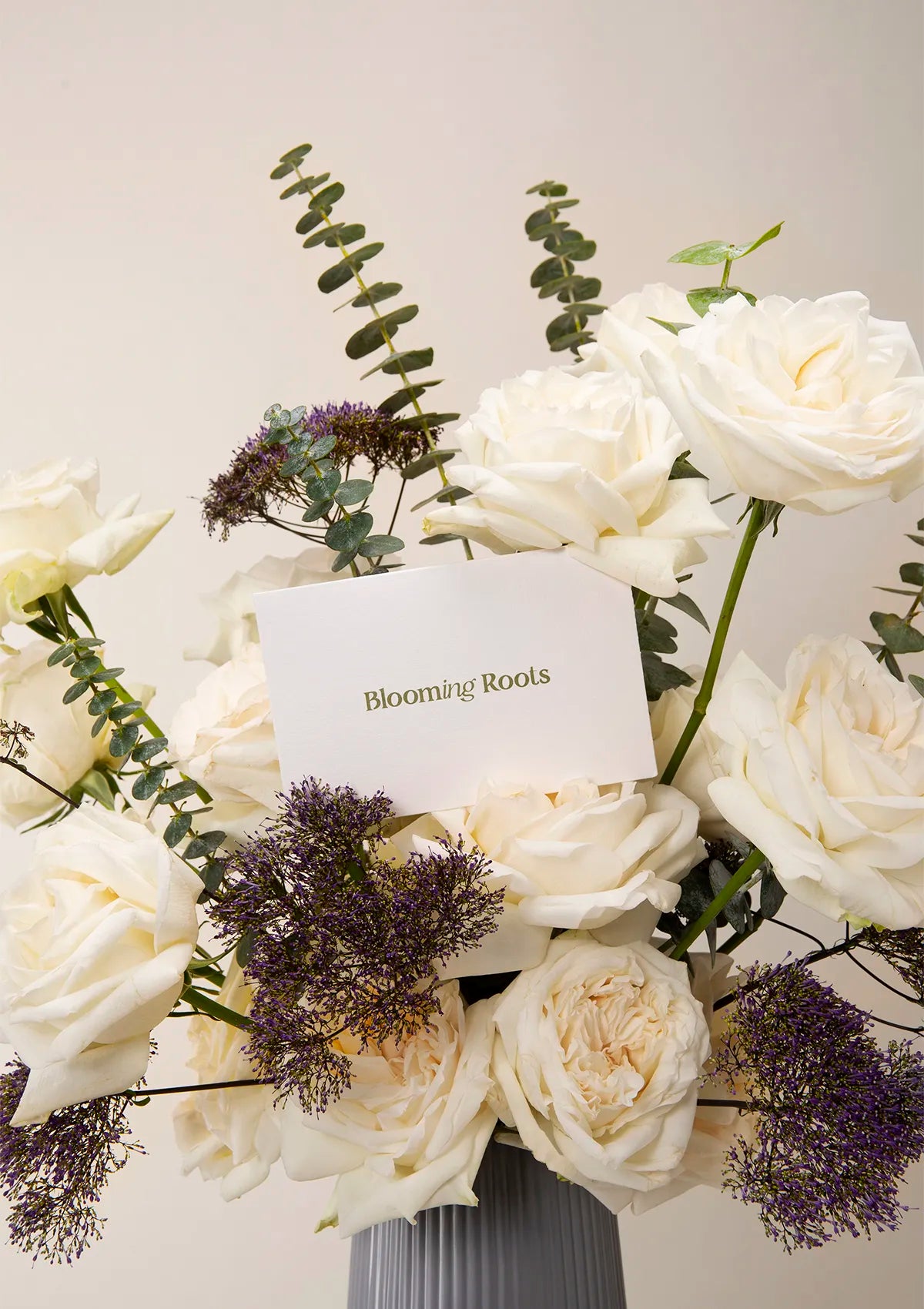 Grey Ceramic Serene Vase by Blooming Roots with a greeting card that has a logo on it.