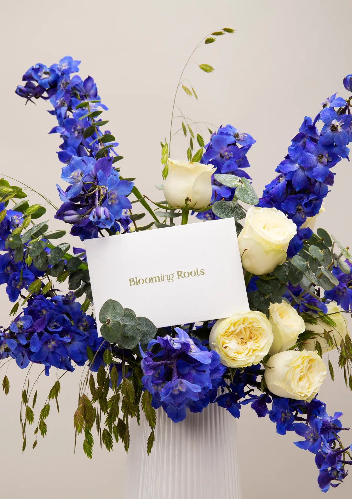 White Ceramic Royal Vase by Blooming Roots with a greeting card that has a logo on it.